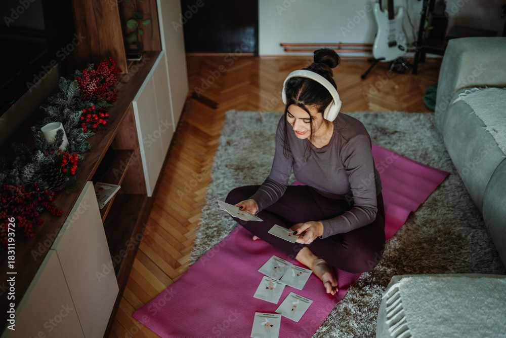 Obraz premium Woman planning home workout using exercise cards