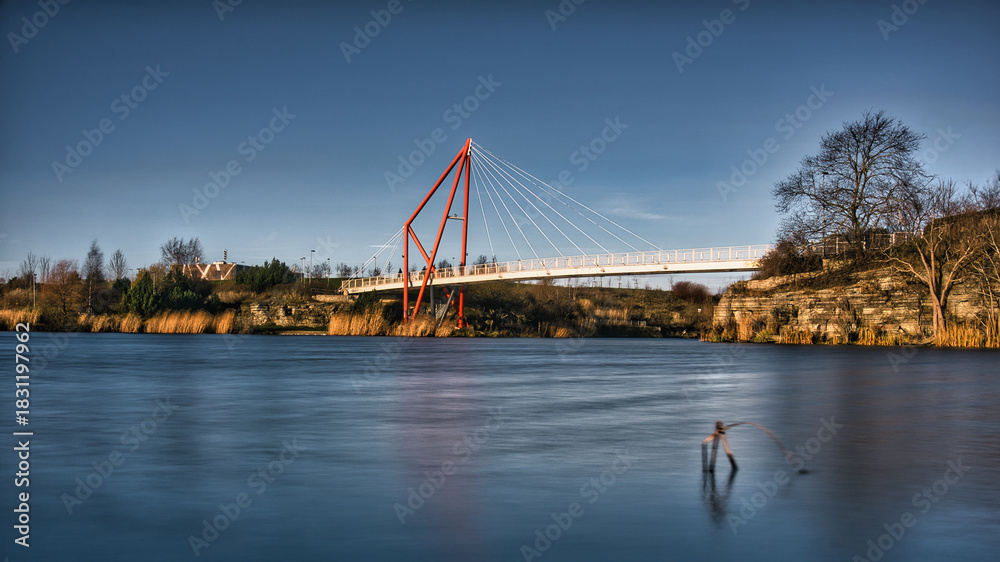 Obraz premium Red Suspension Pedestrian Bridge Over Pae Lake Long Exposure