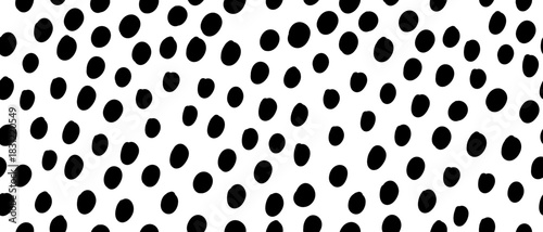 Abstract seamless pattern with uneven polka dots. Hand drawn round elements create a dynamic black and white design. Vector illustration on an isolated background.