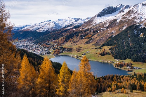 Autumnal mountain panorama in Davos with a view of the lake. Majestic Mountain Landscape, Scenic Valley With Colorful Ridges And Peaks, Serene Mountain Vista With Snowcovered Summits Vibrant Meadows