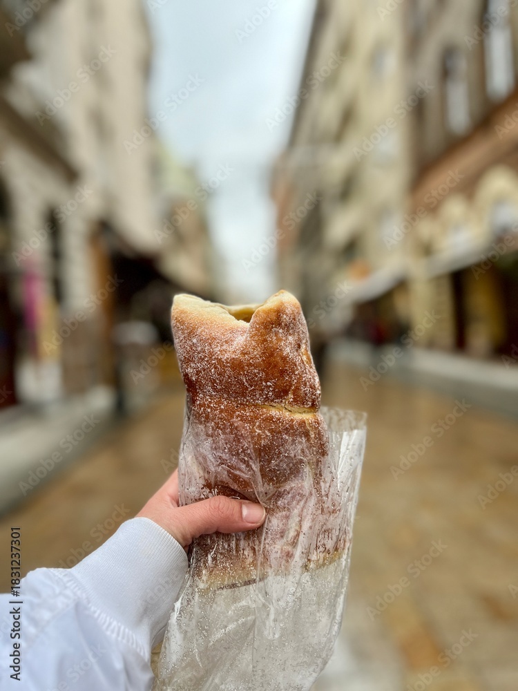 Fototapeta premium Hand holding kurtoskalacs chimney cake in budapest street