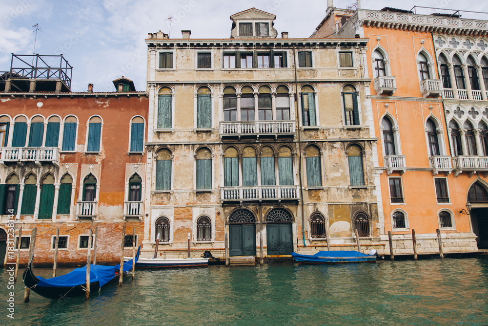 Naklejka premium Venetian canal with historic buildings and gondolas