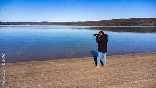 Photographer Taking Landscape Picture by a Lake - Travel and Hobby Concept