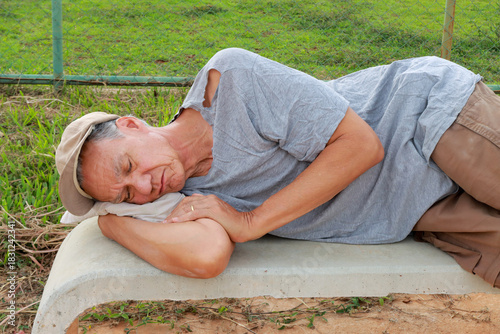 Older Homeless Man taking a nap on a Park Bench