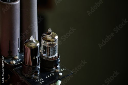 Vintage radio frequency power amplifier electronic module featuring vacuum tubes and capacitors on dark ambient
