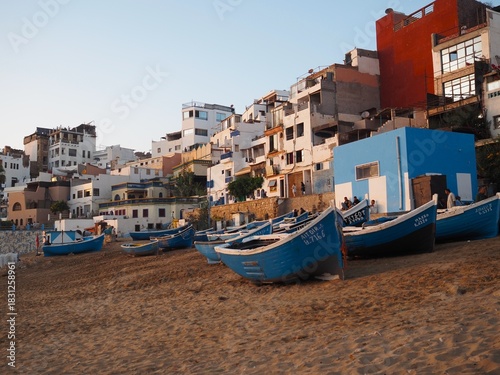 Traditional blue fishermen's boats at sunset on the beach in Taghazout, Morocco