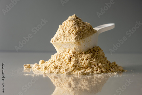 Spoon with protein on colored background.