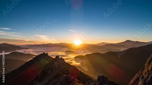 Sunrise over mountainous landscape with clouds and sky rays