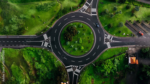 Fotografija Aerial view of a circular intersection surrounded by lush greenery and vibrant l