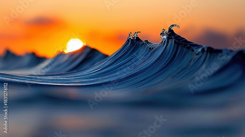 Fototapeta Naklejka Na Ścianę i Meble -  Close-up shot of a wave cresting in the ocean at sunset with an orange sky in the background.