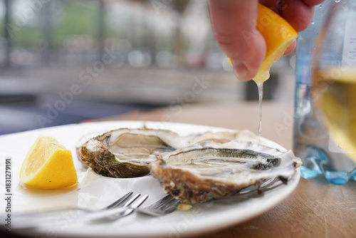 Squeezing lemon on the oyster.