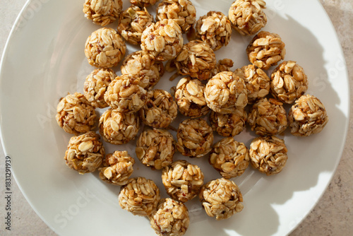 A top down view of a pile of granola balls, on a plate.