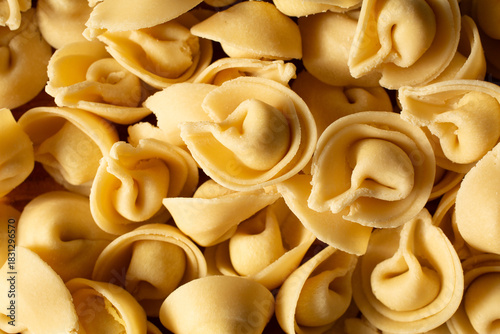 A top down view of a pile of raw gluten-free tortelloni, as a background.