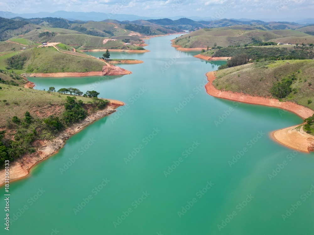 Fototapeta premium Vista do alto a seca da represa cercada de vegetação e natureza com cores vibrantes.