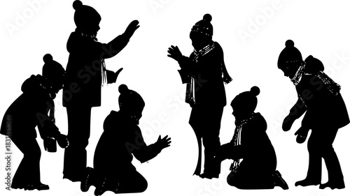 A scene of children in silhouette playing in Christmas or winter cold weather clothing making a snowman 