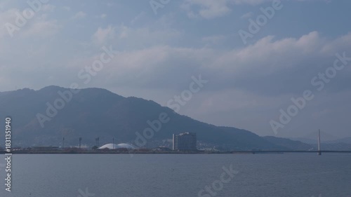 青空と河川、奥に街並みが広がる風景 Urban River Scenery with Blue Sky