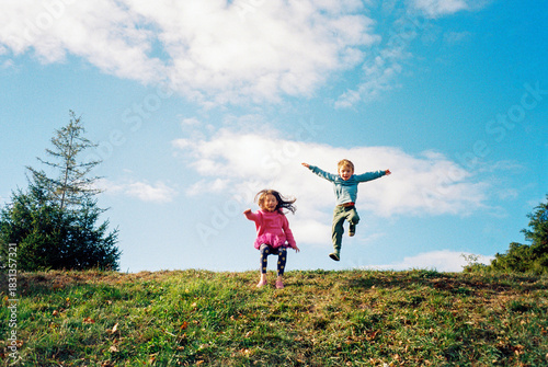 Happy kids jump and play in public park