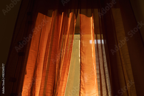 Golden Sunlight Filters Through Sheer Orange Curtains in a Cozy Room