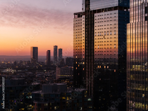 Glass skyscrapers reflecting sunset over Jersey City skyline

