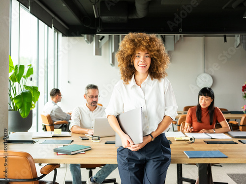 Confident Young Professional Woman Stands  In Modern Office