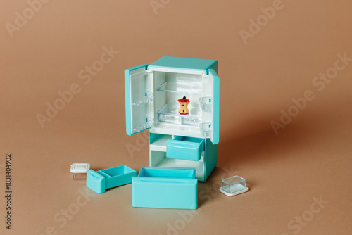 miniature turquoise refrigerator open with a single apple core inside