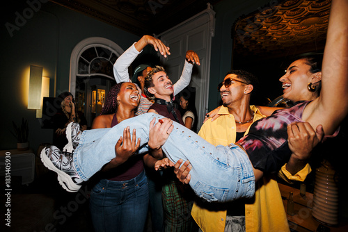 Cheerful young people celebrating together at house party