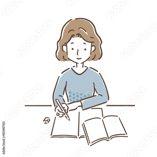 机にノートとテキストを広げて勉強をしている若い女性