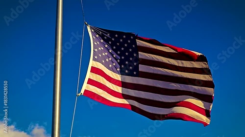 waving American flag on a tall flagpole stretches against a clear blue sky, symbolizing patriotism, freedom, and national pride