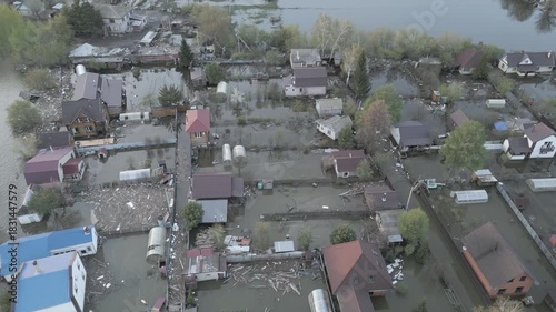 Aerial drone footage showing severe flooding with submerged houses and roads. Wide overhead view of a disaster zone after heavy rainfall, showcasing water damage, extreme weather, and climate-related 