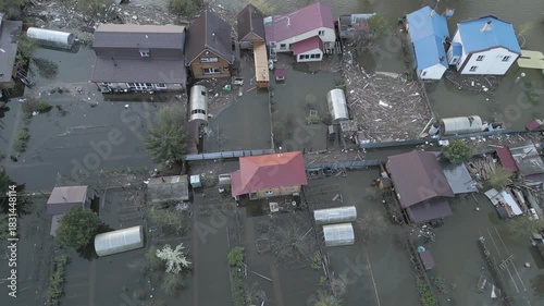 Aerial drone footage showing severe flooding with submerged houses and roads. Wide overhead view of a disaster zone after heavy rainfall, showcasing water damage, extreme weather, and climate-related 