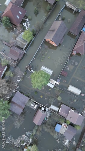 Aerial drone footage showing severe flooding with submerged houses and roads. Wide overhead view of a disaster zone after heavy rainfall, showcasing water damage, extreme weather, and climate-related 
