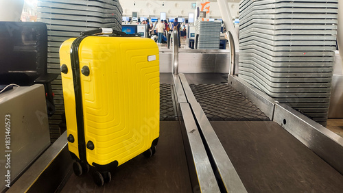 Bright Yellow Suitcase Moving on an Airport Conveyor Belt