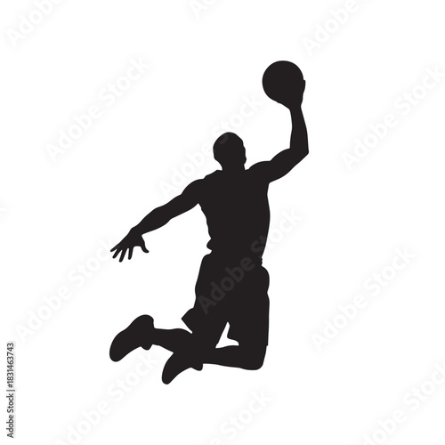 Silhouette of a basketball player in mid air preparing to throw the ball into the basket