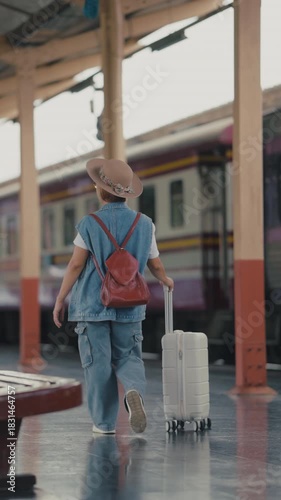 Mature female traveler waiting at train station platform