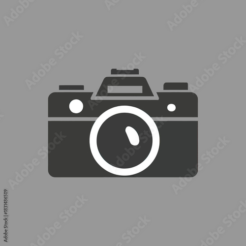 A dark grey retro camera icon with a white lens on a solid light grey background