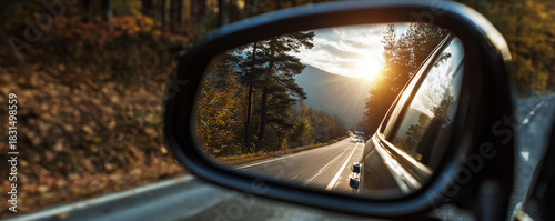 The reflection in a car's rearview mirror shows the sunset. Concept of travel, freedom, vacation
