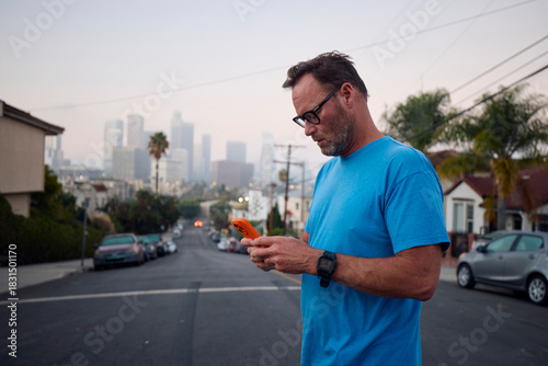 Man sending texts while on the street