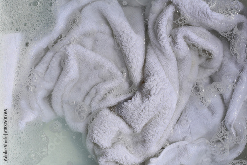 Cuadro en lienzo White towel soaking in a basin of soapy, bubbly water.
