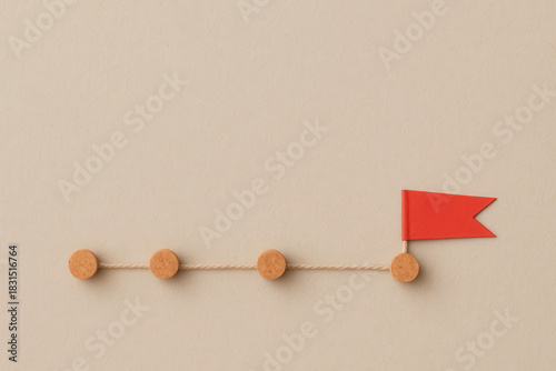 Strategic plan for achieving success often involves setting clear goals represented by markers along path. Each step signifies progress toward ultimate objective, symbolized by flag