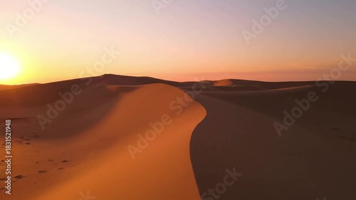 Exploring the subtle transitions of color in the sky during sunrise or sunset, reflected in the smooth, undulating surfaces of the sand. Mid shot, eye level