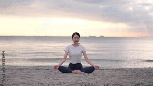 夕方の海辺でヨガをする女性のサークルショット