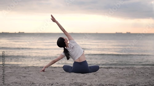 夕方の海辺でヨガをする女性の後ろ姿