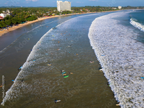 Aerial view of Weligama Beach with surfers riding the waves, Sri Lanka