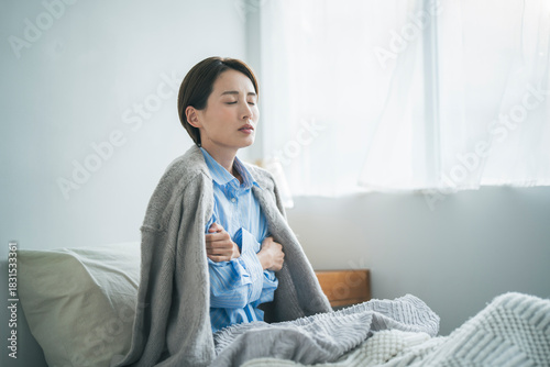 風邪をひき、寒さで震えている女性