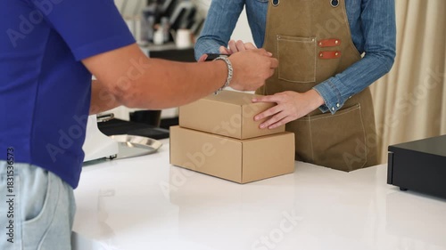 Deliveryman confirming parcel with cafe owner woman using smartphone, representing digital signature, cashless payment, efficient collaboration between delivery service and small business logistics