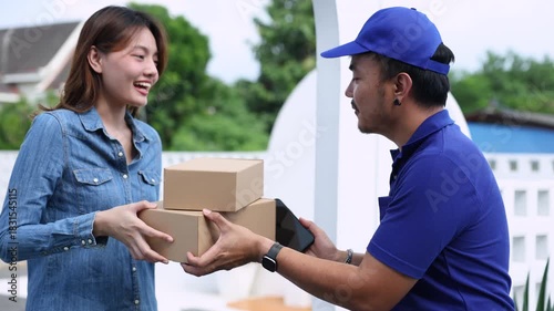 Delivery man handing parcel boxes to Asian customer woman at house gate, friendly courier representing reliable logistics, customer satisfaction, and small business delivery service partnership