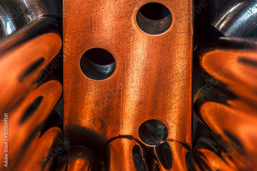 Copper busbar closeup, on a convex metal surface, forming abstract curves, a concept of the fluidity of non-ferrous metals