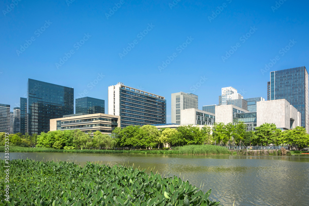 Obraz premium Serene Urban Oasis: A Stunning View of Cityscape Reflected in Tranquil Waters