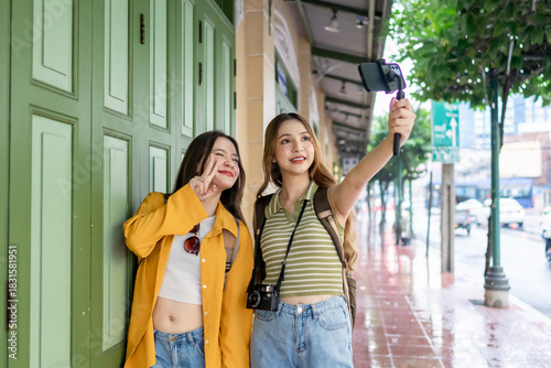 Two Asian women using phone recording vlog while traveling in the city. 