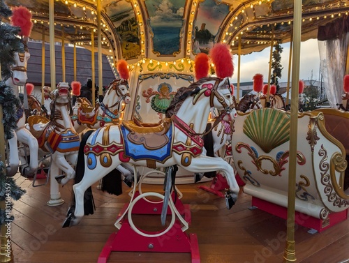merry go round. Vintage Christmas carousel with painted horses and glowing lights at a winter fair. Festive amusement ride atmosphere.